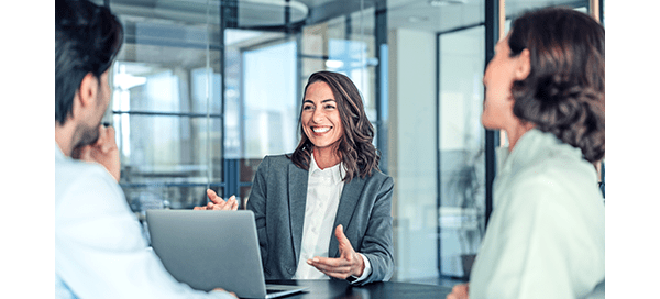Woman in grey suit smiling above computer