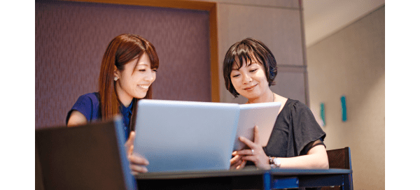 Women comparing notes on technical devices