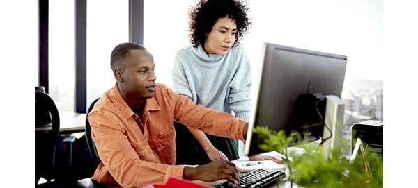 Man and woman pointing at computer screen
