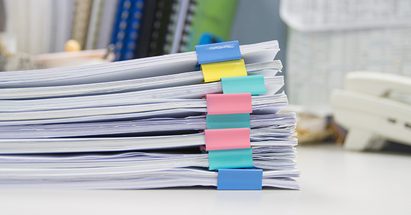 Stacked papers with colorful bookmarks